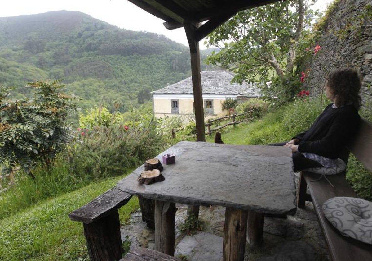 Una turista disfruta de las vistas desde una casa rural asturiana.