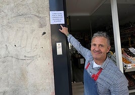 José Antonio Blanco González, junto al cartel que ha colgado en su tienda.
