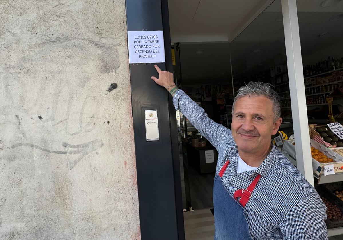 José Antonio Blanco González, junto al cartel que ha colgado en su tienda.