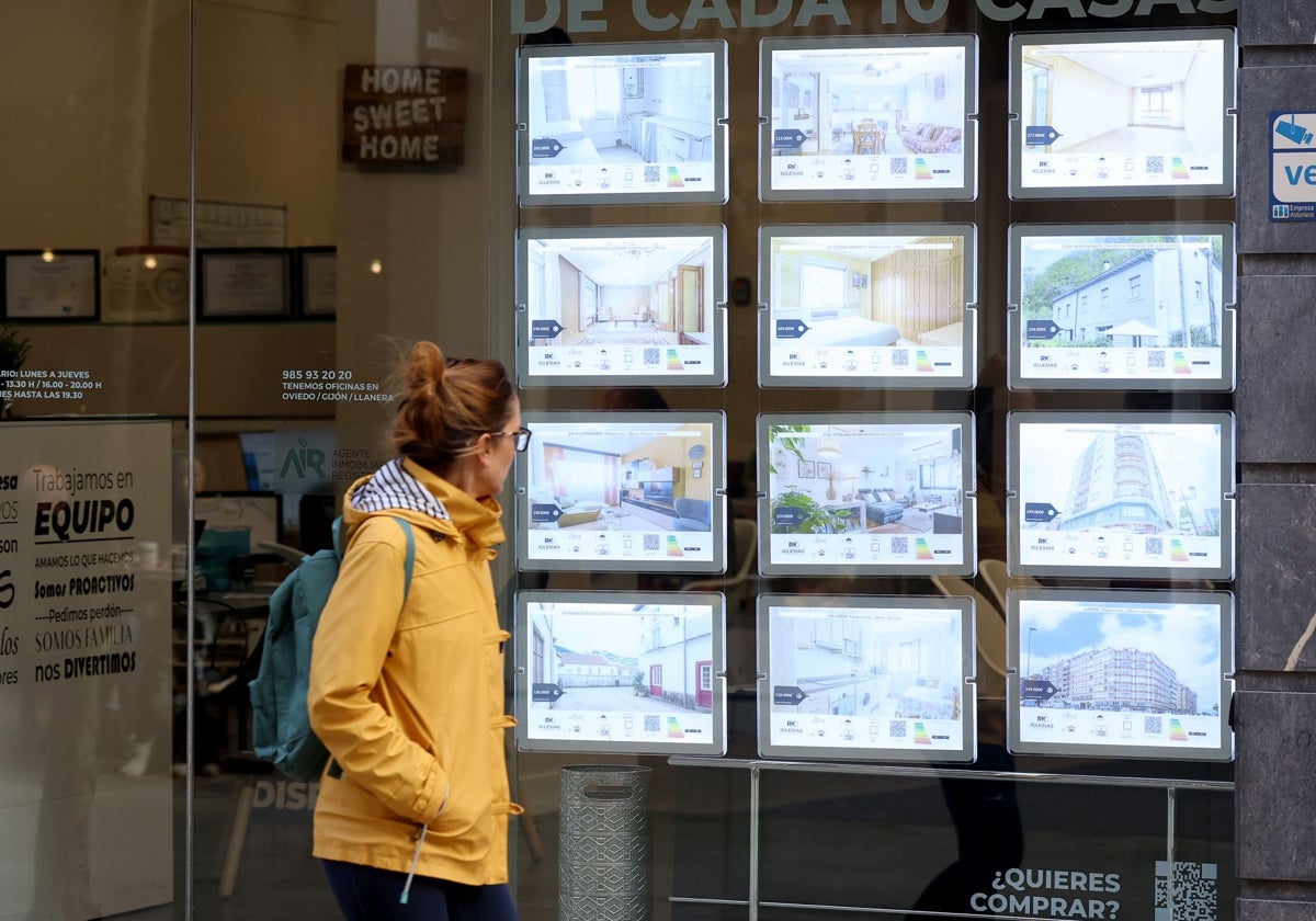 Una mujer observa las ofertas de una inmobiliaria de Oviedo.