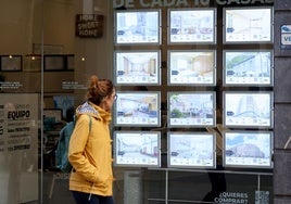 Una mujer observa las ofertas de una inmobiliaria de Oviedo.