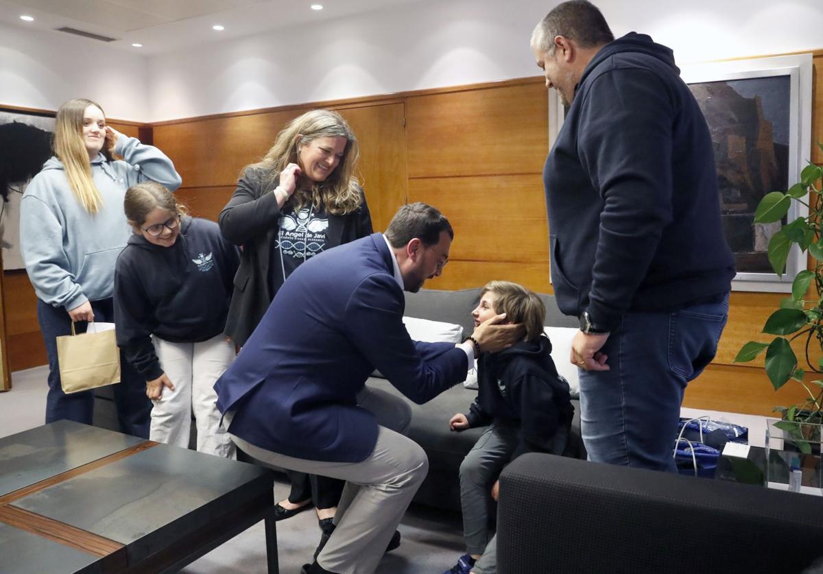Adrián Barbón, con Javi, el niño de ocho años que padece la enfermedad de Nedamss, y su familia.