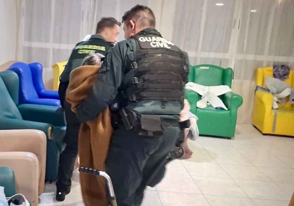 Dos agentes de la Guardia Civil evacuan a un usuario de la residencia geriátrica en La Barganiza.