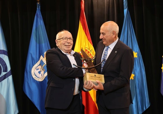 Aquilino Caramés recibe el premio de manos del presidente del Centro Asturiano, Gerardo Martínez.