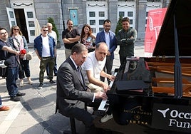 Alfredo Canteli toca el piano frente al Teatro Campoamor en Oviedo.