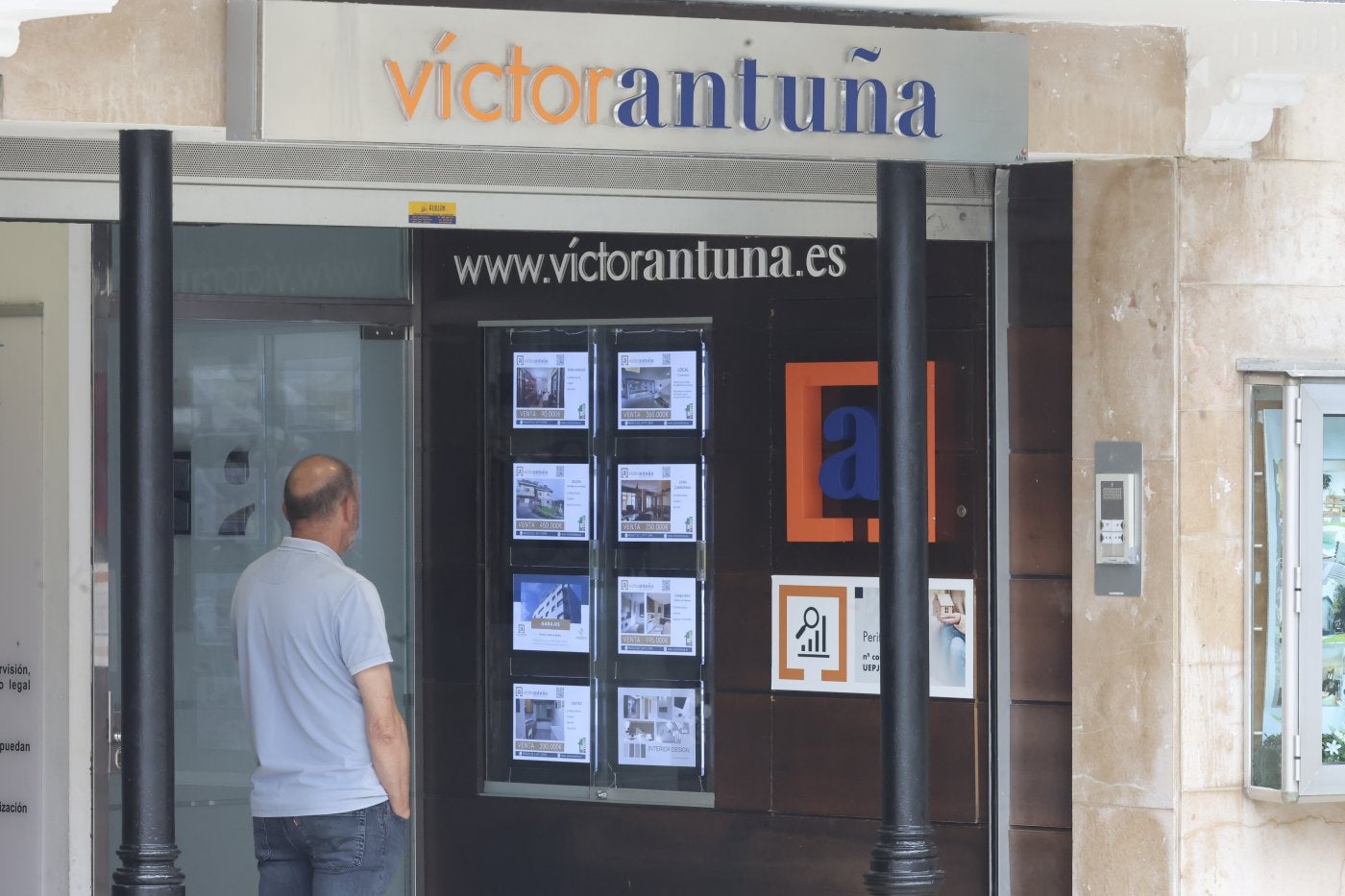 Un hombre mira la oferta de vivienda que se encuentra en el exterior de la inmobiliaria Víctor Antuña.