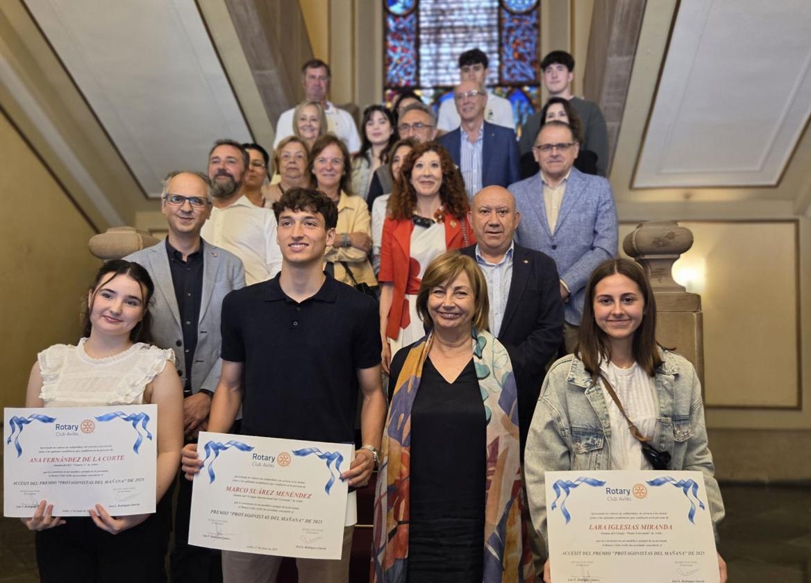 Ana Fernández de la Corte, Marco Suárez Menéndez y Lara Iglesias, junto a la alcaldesa. Detrás, el concejal de Educación, el presidente del Rotary, familiares y profesores.