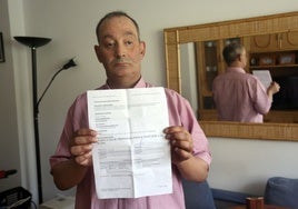 Francisco Javier Iglesias con el papel de su certificado médica en su domicilio.