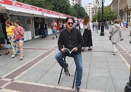Jaime Priede posa con un libro en el paseo de Begoña.