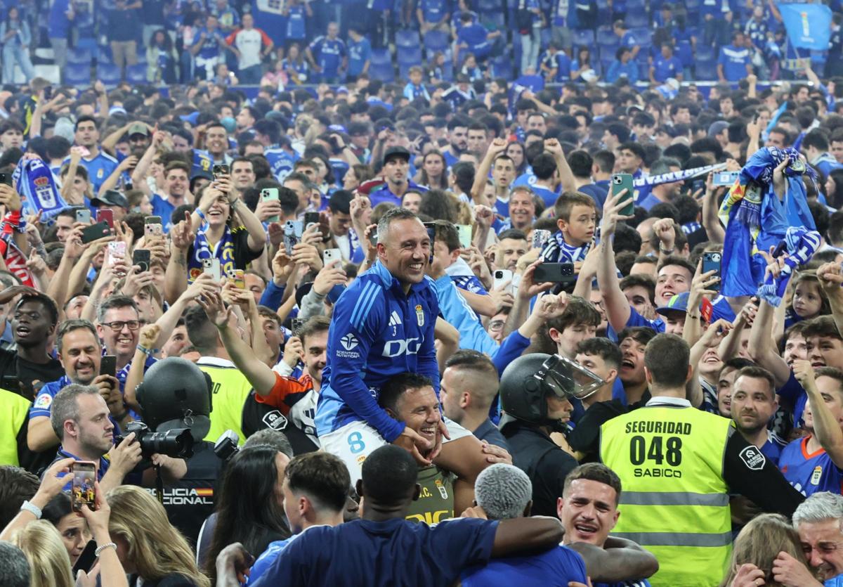 Cazorla, a hombros rodeado de la afición del Real Oviedo, que tomó el campo del Tartiere.