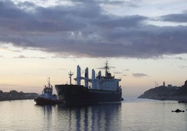 Un barco accede al Puerto de Avilés asistido por un remolcador.