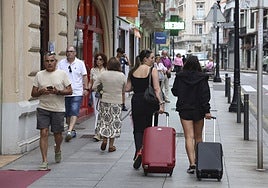 Vecinos y turistas pasendo por el centro de Gijón.