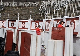 Oficiales de pintura de los planes de empleo retocando la parte inferior de los tendidos, el callejón y los burladeros de El Bibio.