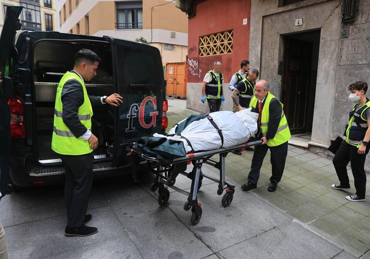 Los servicios sanitarios trasladan el cadáver de la mujer en presencia de la Policía Nacional, en la calle Contracay.