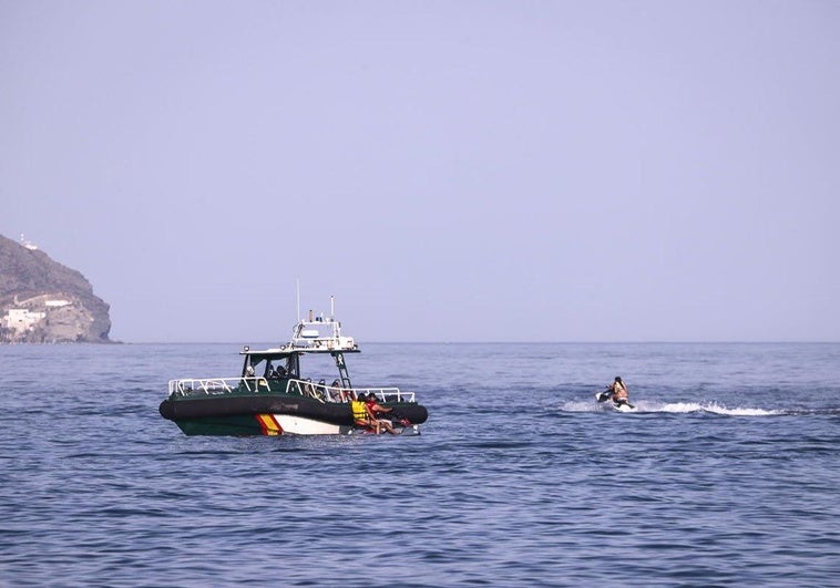La Guardia Civil advierte a unos jóvenes que van en moto de agua.