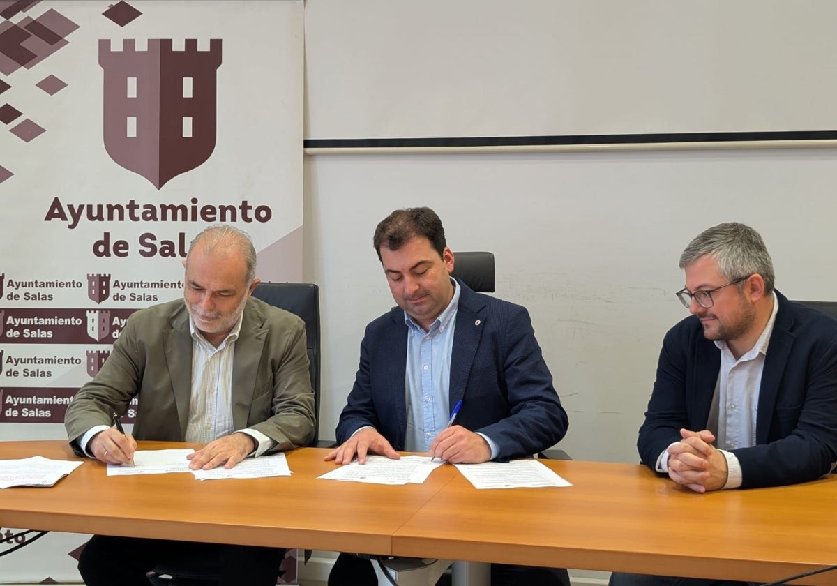 José Manuel Ferreira y el alcalde, Sergio Hidalgo, firman en convenio en presencia del concejal de Promoción Económica del Ayuntamiento de Salas, Alejandro Bermúdez.