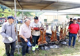 Los vecinos durante la preparación de los corderos a la estaca en Santianes.