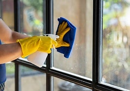 Una persona limpia las ventanas de su casa.