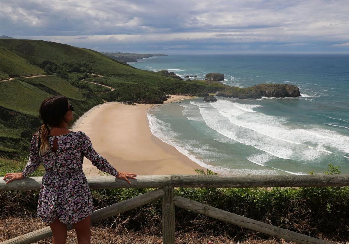 Una mujer disfruta de las vistas a la playa de Torimbia, en Llanes.