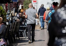 Un camarero atiende una terraza.