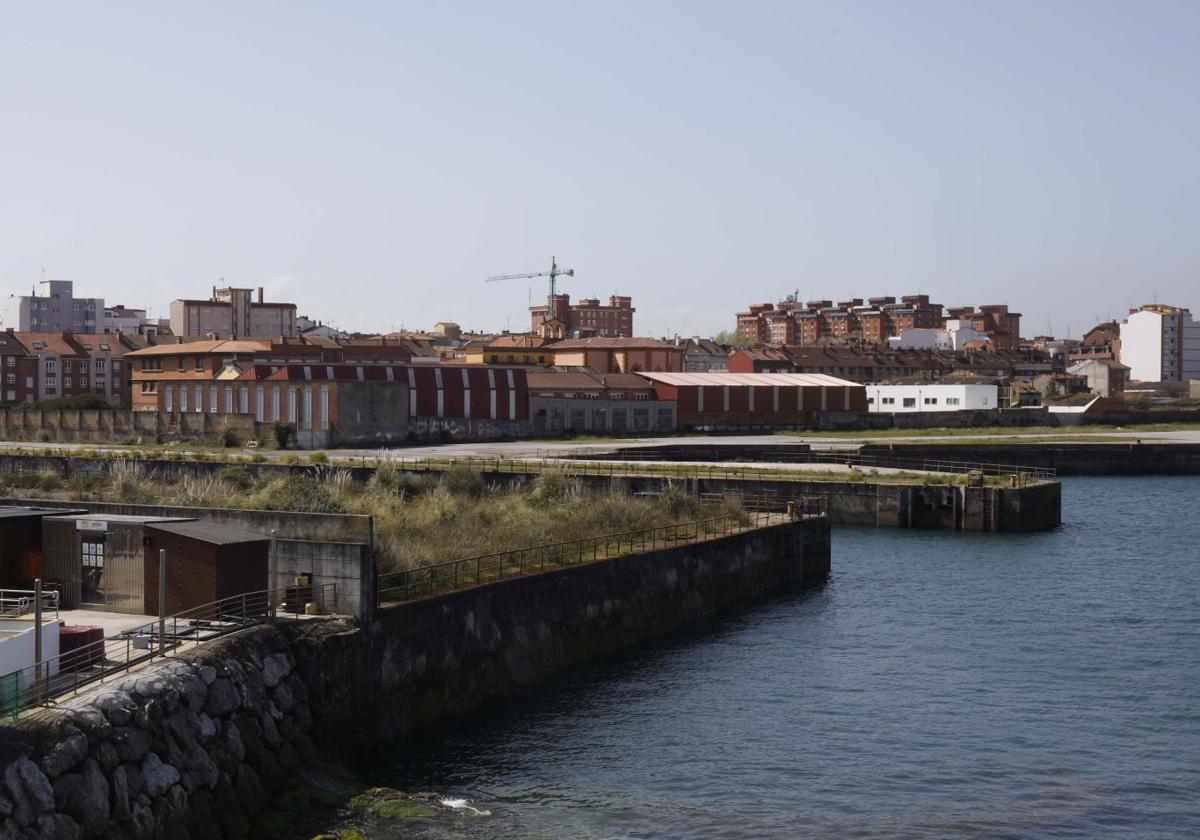 Panorámica de la franja litoral de los terrenos de los antiguos astilleros Naval Gijón, con la dársena en primer término.