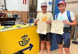 Dos peregrinos muestran las bolsas de tela gratuitas.