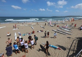 Un grupo de surfistas se prepara para salir a la mar en una de las muchas competiciones que se celebran durante el año en la playa de Salinas.