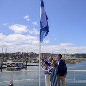 Nieves Roqueñí, Flor Guardado y Jorge González-Palacios izan la Bandera Azul este miércoles en el Puerto Deportivo de Gijon.