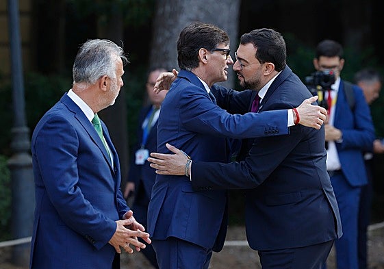 Salvador Illa y Adrián Barbón se saludan ante la mirada del ministro de Política Territorial, Ángel Víctor Torres, a su llegada a la Conferencia de Presidentes celebrada el pasado mes de junio en Barcelona.