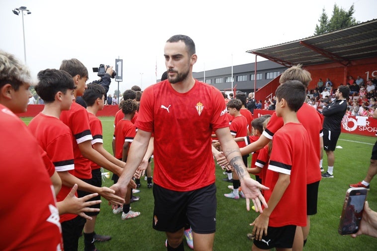 Los jugadores del Sporting de Gijón llegan al campo de entrenamiento atravesando el pasillo de los niños del campus con Perrin en primer término.