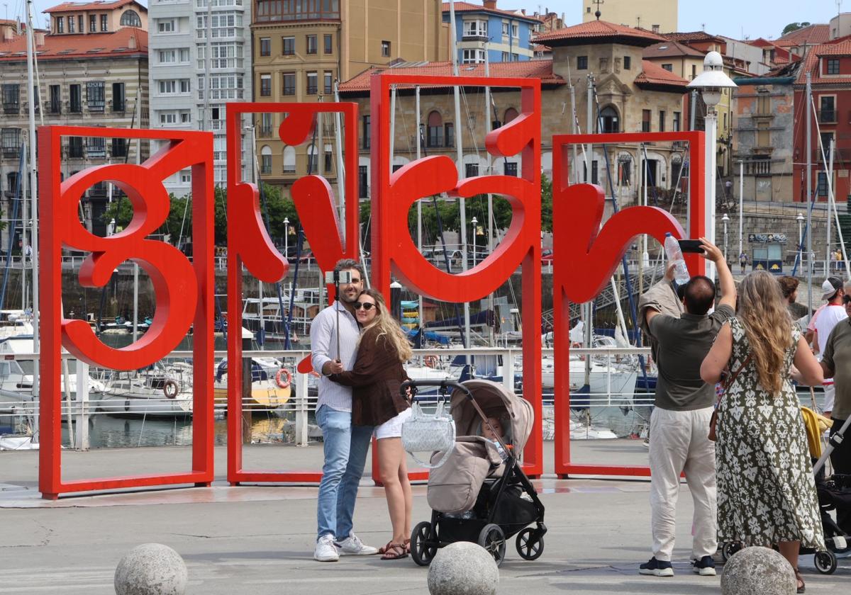 Un grupo de turistas se inmortaliza antes las 'Letronas' de Gijón.