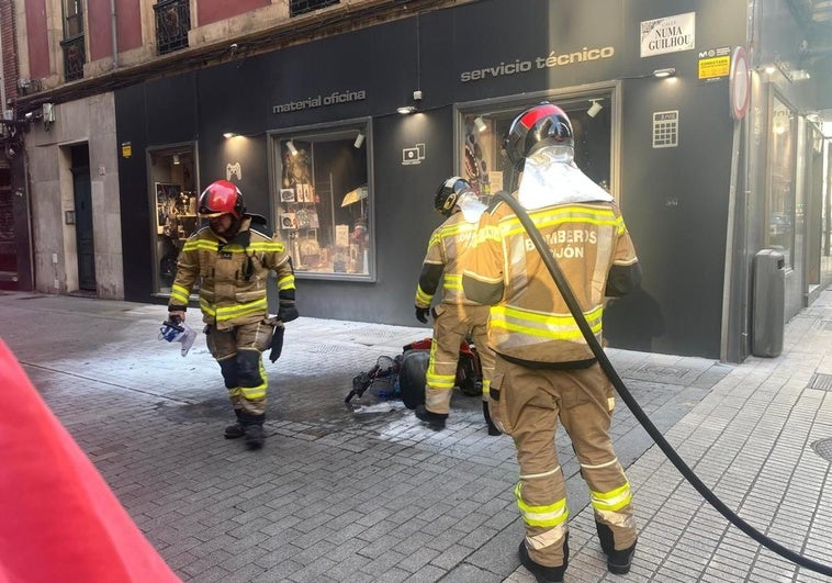 Los bomberos, con la silla de ruedas incendiada.