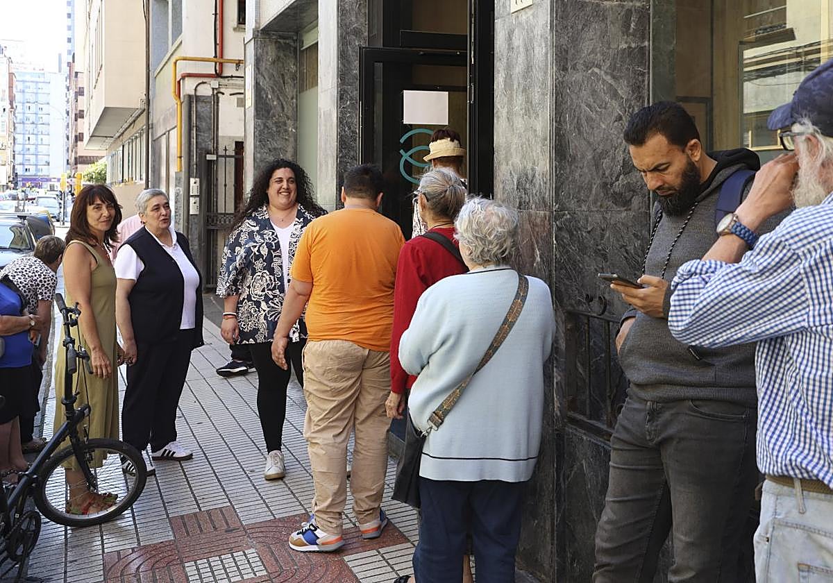 Marieta Mata, sor Mar Martiño y Andrea Bécares saludan a los usuarios de la Cocina Económica en la puerta de la Asociación.