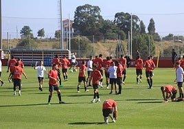 Asier Garitano charla con Juan Otero en la sesión de entrenamiento del Sporting de Gijón de ayer.