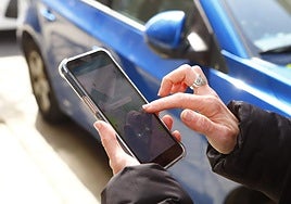 Una mujer realiza el pago de la zona azul.