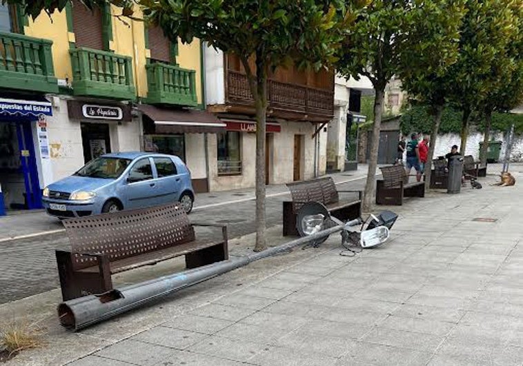 Unos operarios municipales de Laviana derriban una farola con la máquina barredora