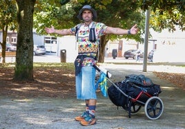 David Giménez posa con 'Charlie', su mochila-carro, en un parque de Avilés donde pasó la noche de este viernes.