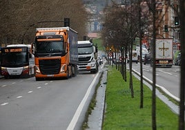 Camiones cruzan la avenida Príncipe de Asturias, con origen o destino en el puerto de El Musel, en Gijón.