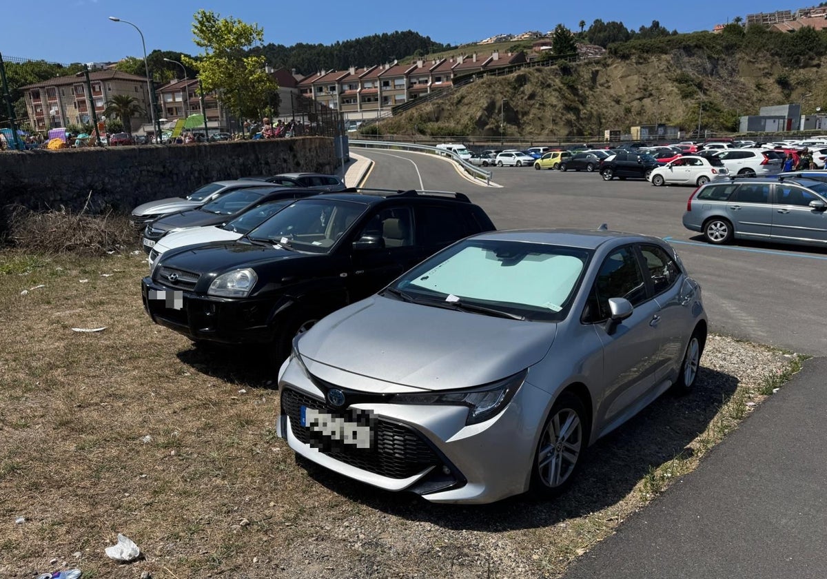 Coches multados en el aparcamiento del puerto deportivo de Luanco, junto a la playa