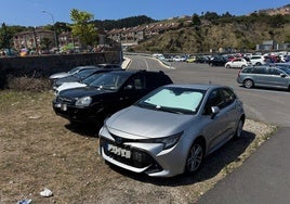 Coches multados en el aparcamiento del puerto deportivo de Luanco, junto a la playa