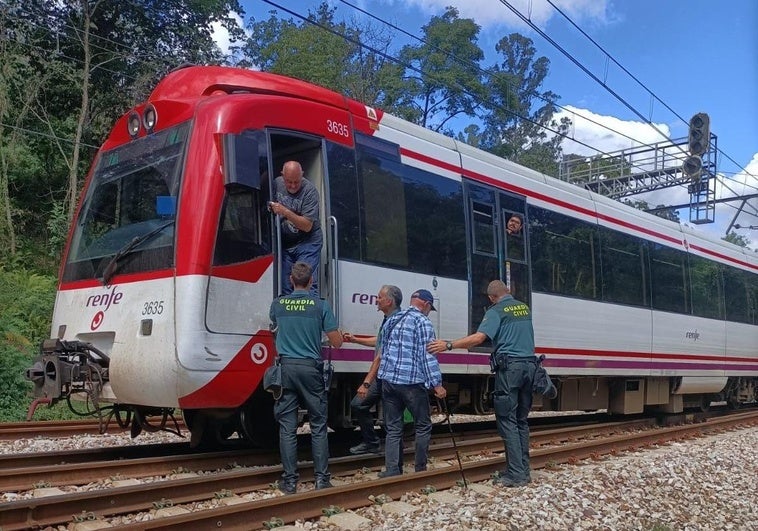 Agentes de la Guardia Civil evacúan a los pasajeros del tren en Siero.