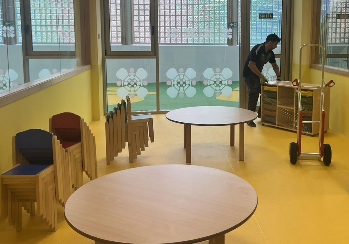 Un operario, al fondo, coloca el nuevo mobiliario de la escuela de 0 a 3 años de La Pola.