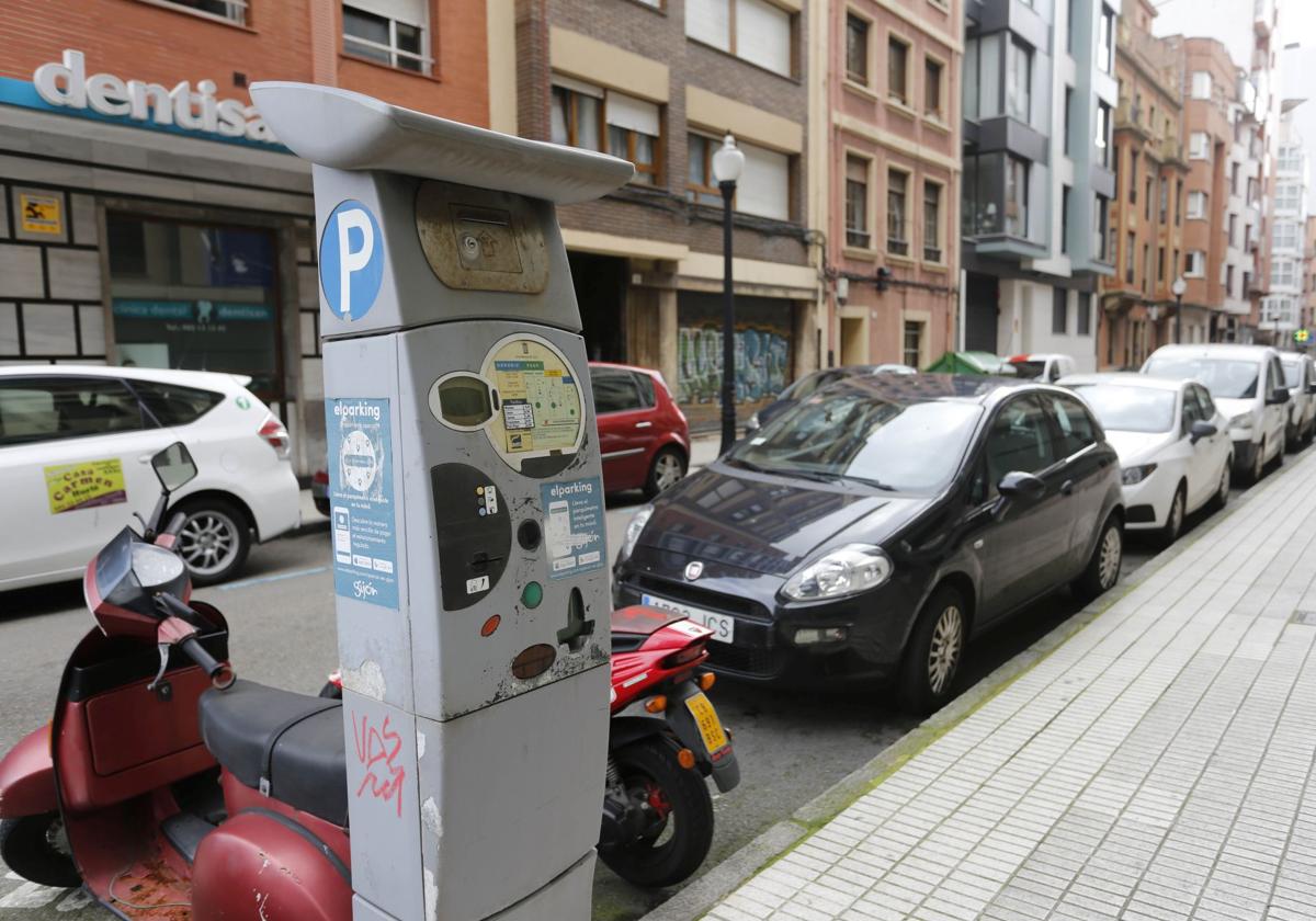 En primer término, un parquímetro de la ORA en una calle de Gijón.