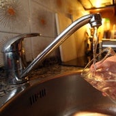 Una persona llena un vaso con agua del grifo.