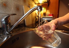 Una persona llena un vaso con agua del grifo.