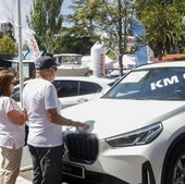 Dos personas ante un coche kilómetro cero en la Feria.