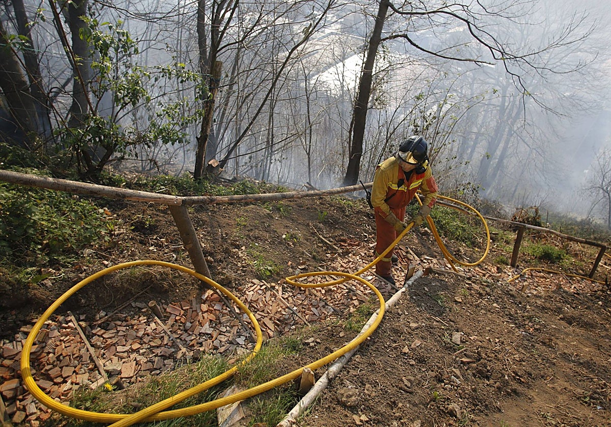 Un bombero realiza trabajos de extinción de un incendio forestal en Mieres