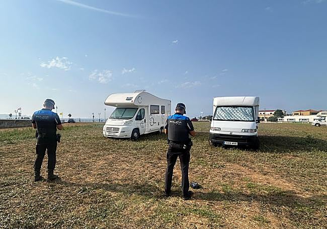 Agentes formalizando las sanciones a dos autocaravanas en la playa verde del Rinconín.