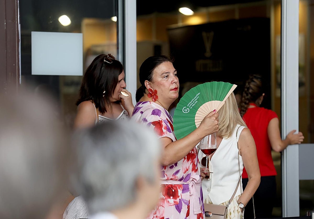Una visitante de la Feria Internacional de Muestras de Asturias, abanicándose para aliviar el calor.
