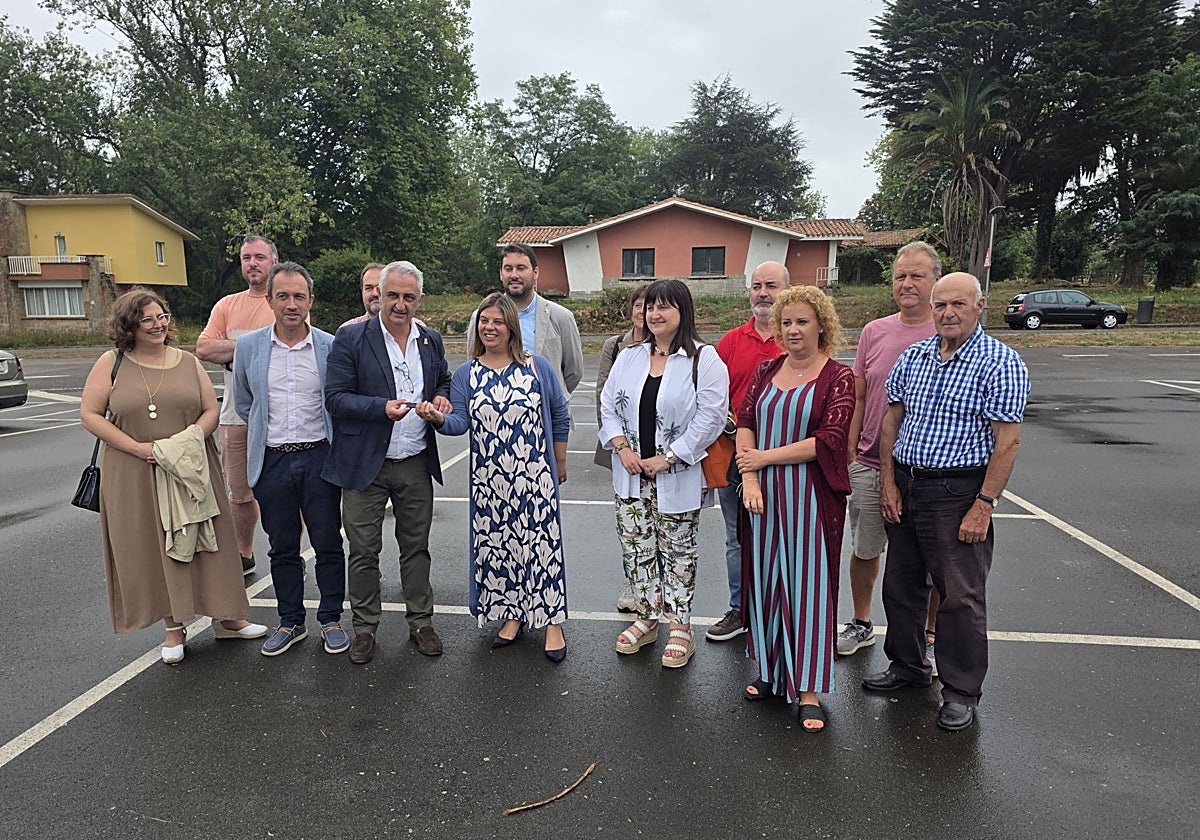 Gimena Llamedo entrega, en Perlora, el pendrive con el plan para el recinto al alcalde, Ángel García, delante del consejero Oviedo Zapico.